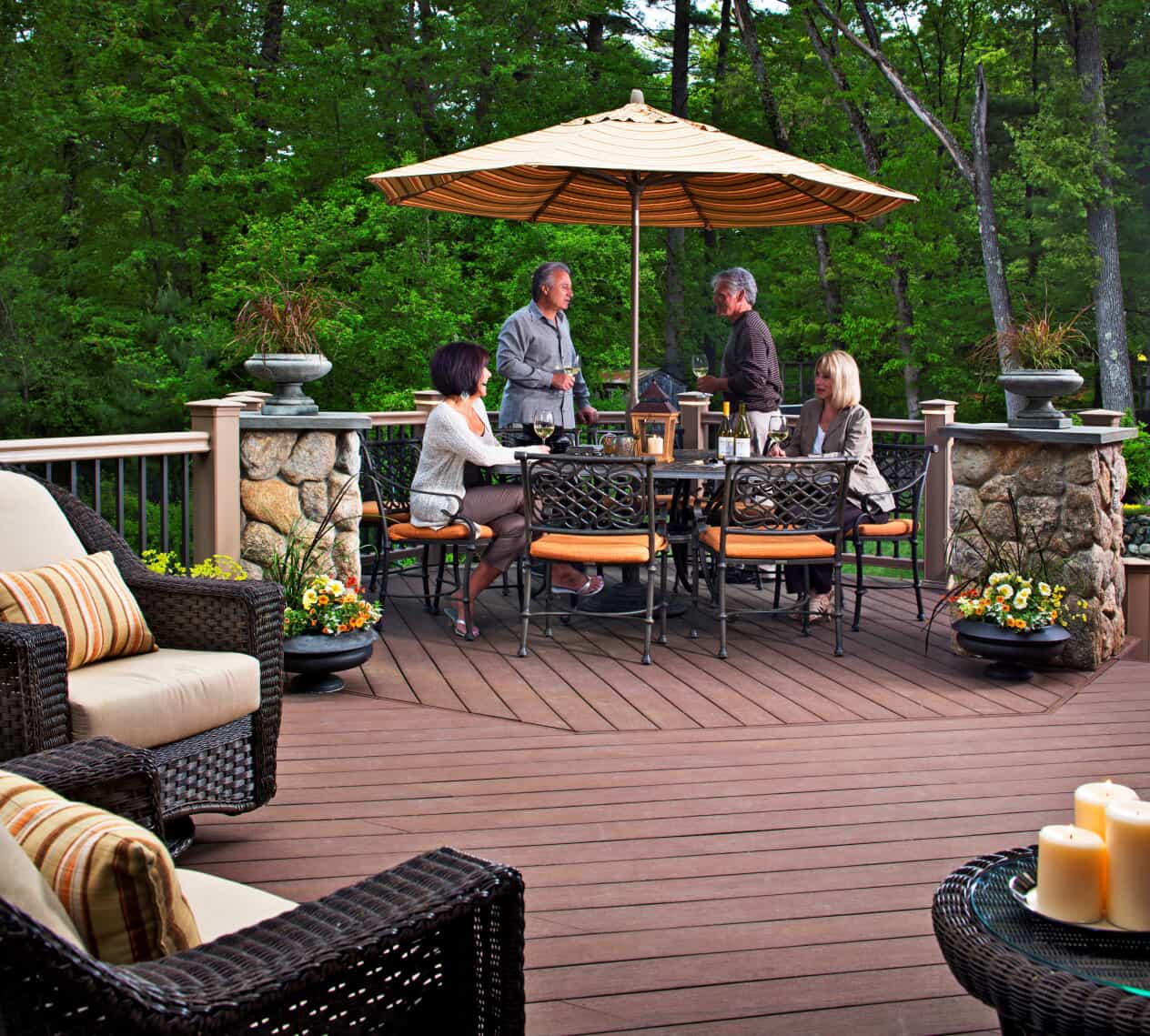 4 individuals around a patio set on a deck.